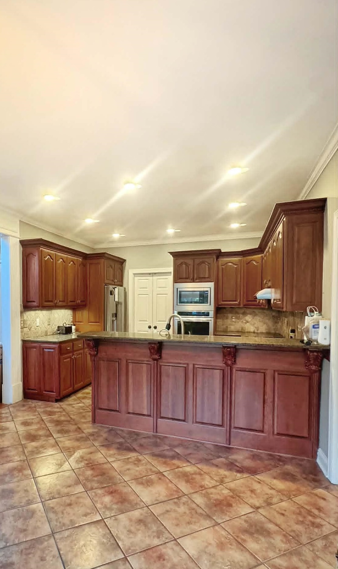 37 Crownpointe Cove Jackson, TN 38305 - Photo 10 of 39 Kitchen featuring extensive cabinetry with decorative corbels, granite countertops, and a tile backsplash