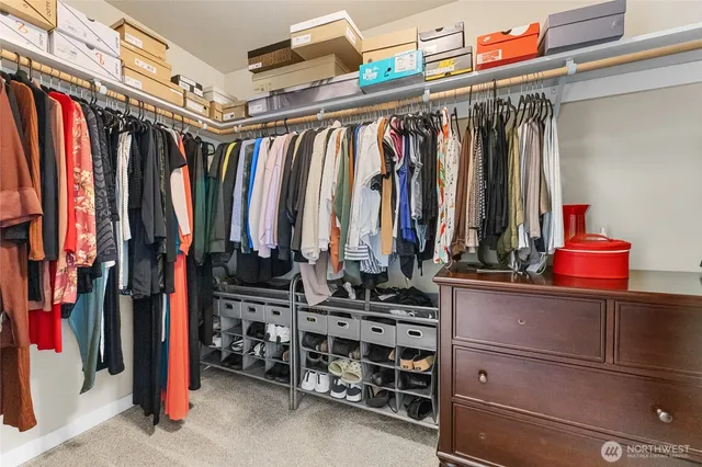 a view of walk in closet with clothes and shoes