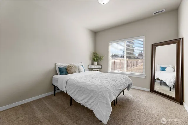a bed sitting in a bedroom next to a window