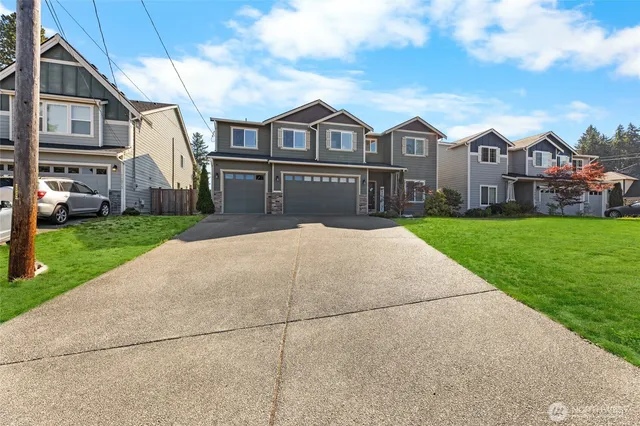 a front view of a residential houses with yard and green space