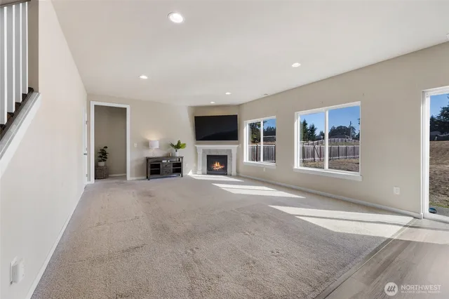 a view of a livingroom with a fireplace a exposed radiator and a window