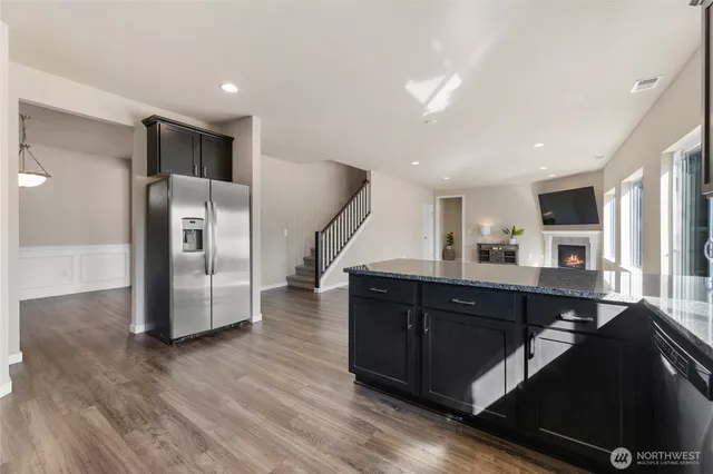 a kitchen with stainless steel appliances a refrigerator and wooden floor