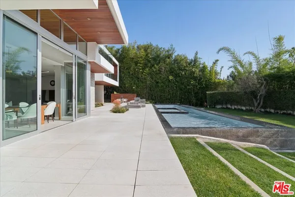 a view of a backyard with plants and a patio