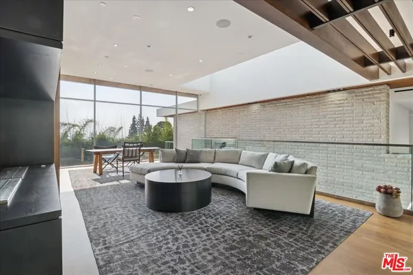 a living room with patio furniture and a potted plant