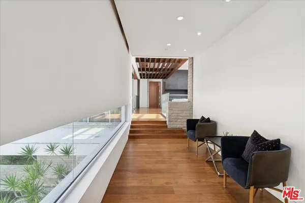 a hallway with couches and wooden floor