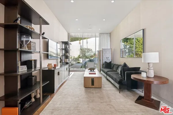 a living room with fireplace furniture and a large window