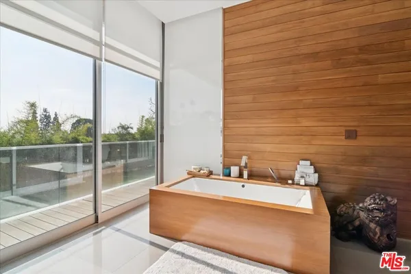 a large white kitchen with a large window and stainless steel appliances
