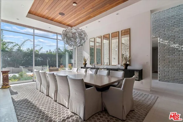 a dining room with furniture a chandelier and wooden floor