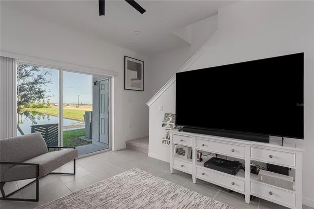 a living room with flat screen tv and floor to ceiling window