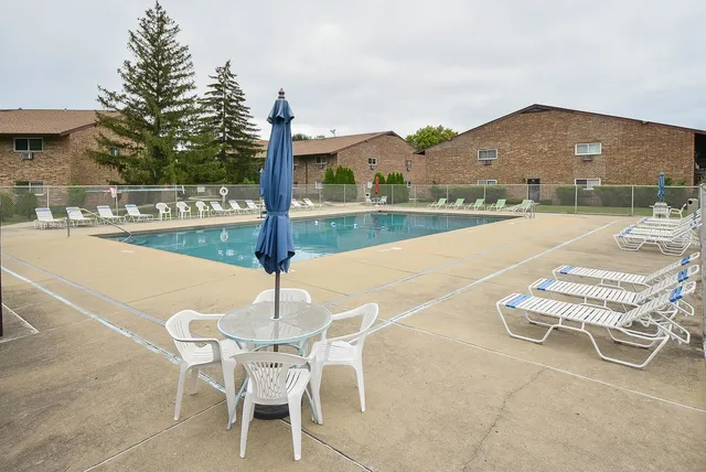 a view of a patio with a table chairs and a swimming pool