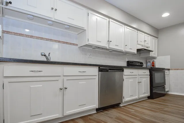 a kitchen with granite countertop white cabinets and white appliances
