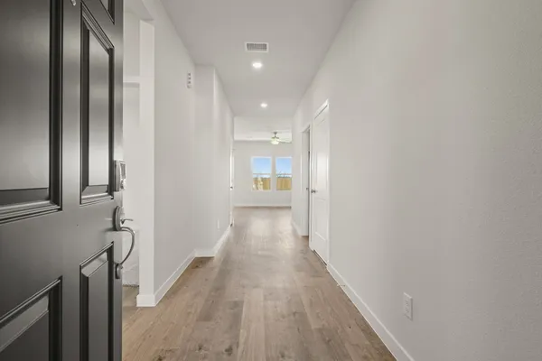 a view of a hallway with wooden floor