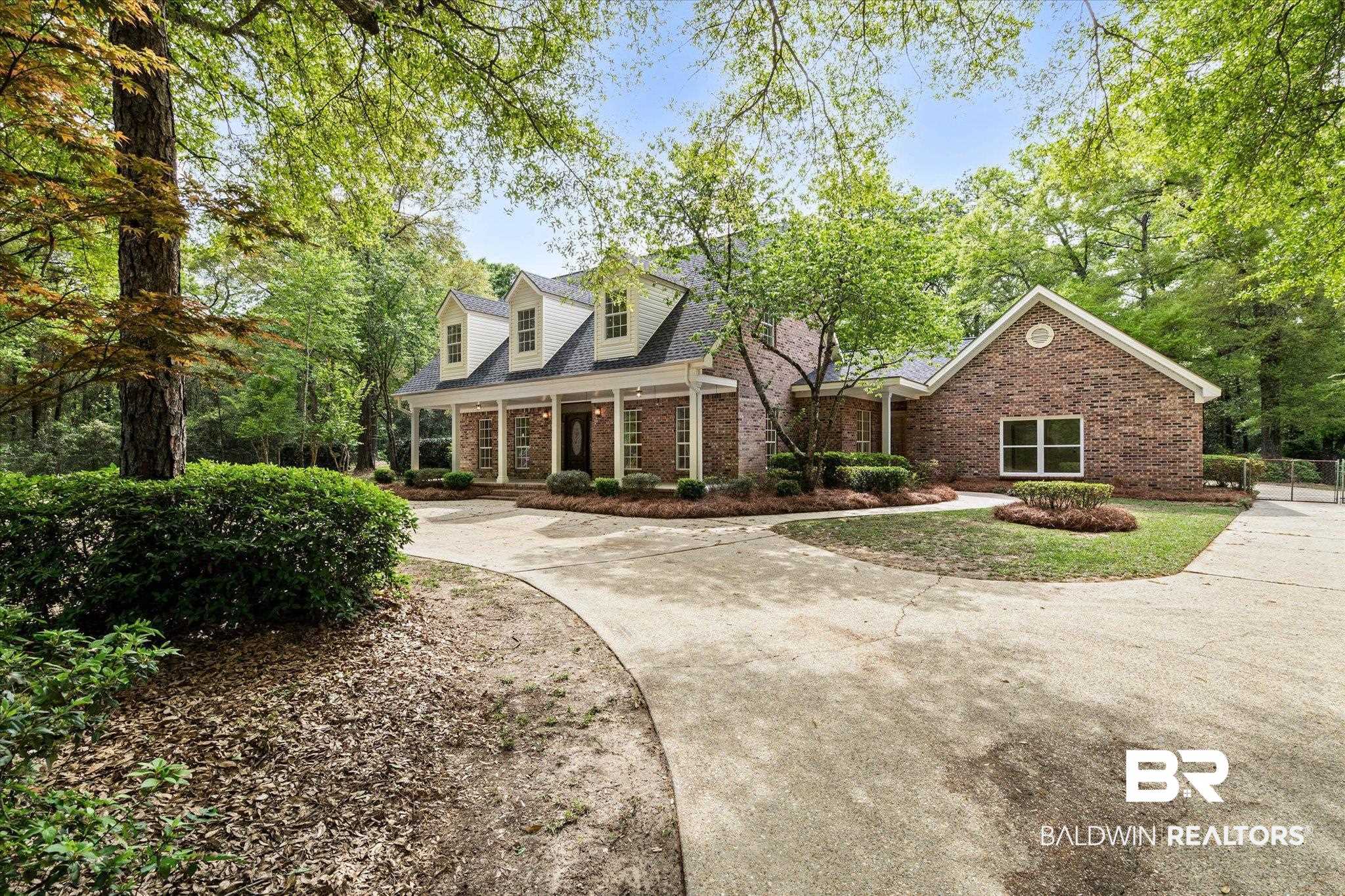 3451 Lacoste Road Mobile, AL 36618 - Photo 33 of 36 Cape cod-style house featuring covered porch, curved driveway, and brick siding