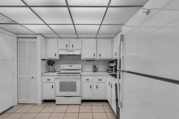 a kitchen with stainless steel appliances a stove a sink and white cabinets