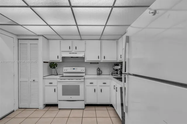 a kitchen with stainless steel appliances a stove a sink and white cabinets