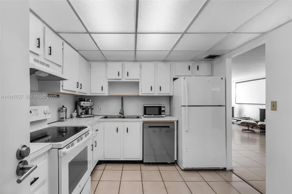 a kitchen with cabinets a sink and white appliances
