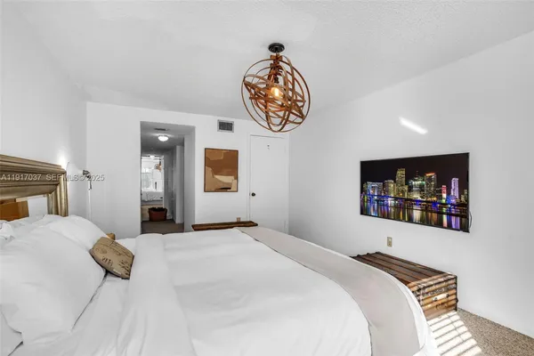 a bedroom with a bed and a painting on the wall