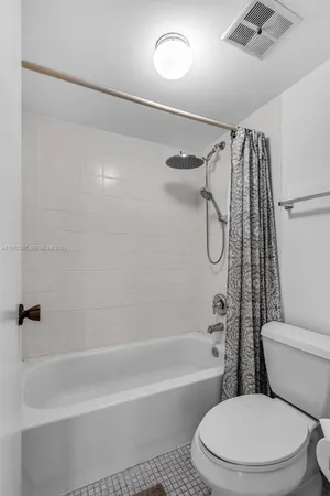 a white toilet and tub sitting next to a bathroom sink