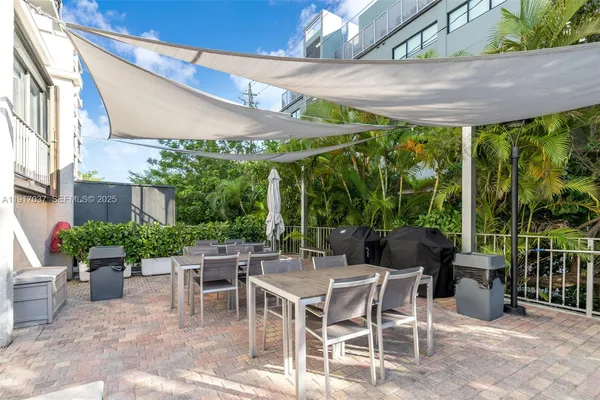 a view of a patio with a table and chairs and potted plants