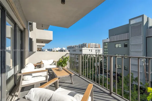 a balcony with table and chairs