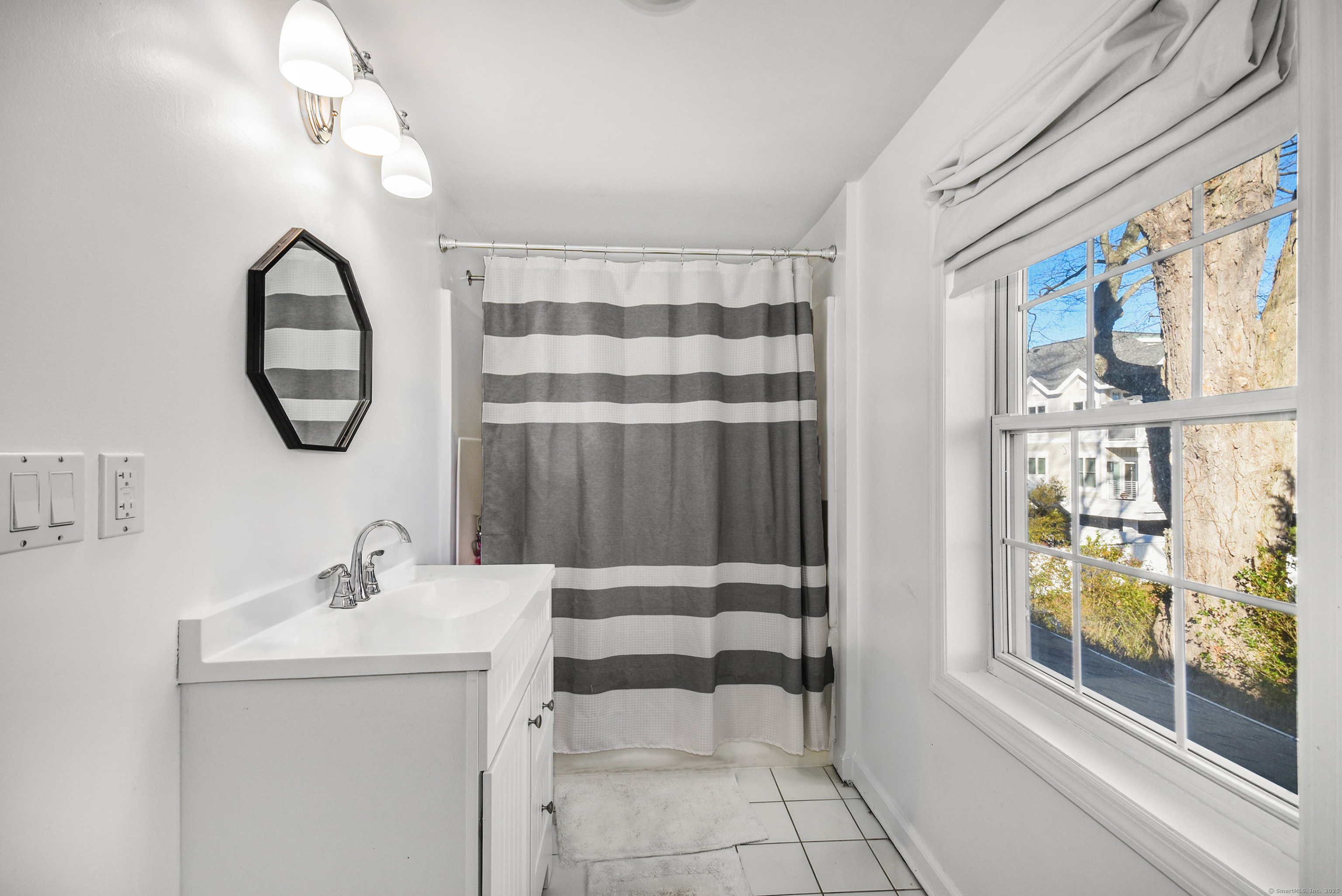 60 East Avenue New Canaan, CT 06840 - Photo 18 of 24 a bathroom with a sink a mirror and a shower