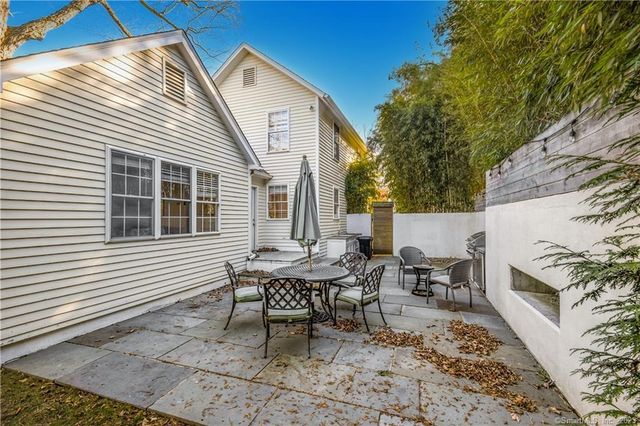 a backyard of a house with table and chairs