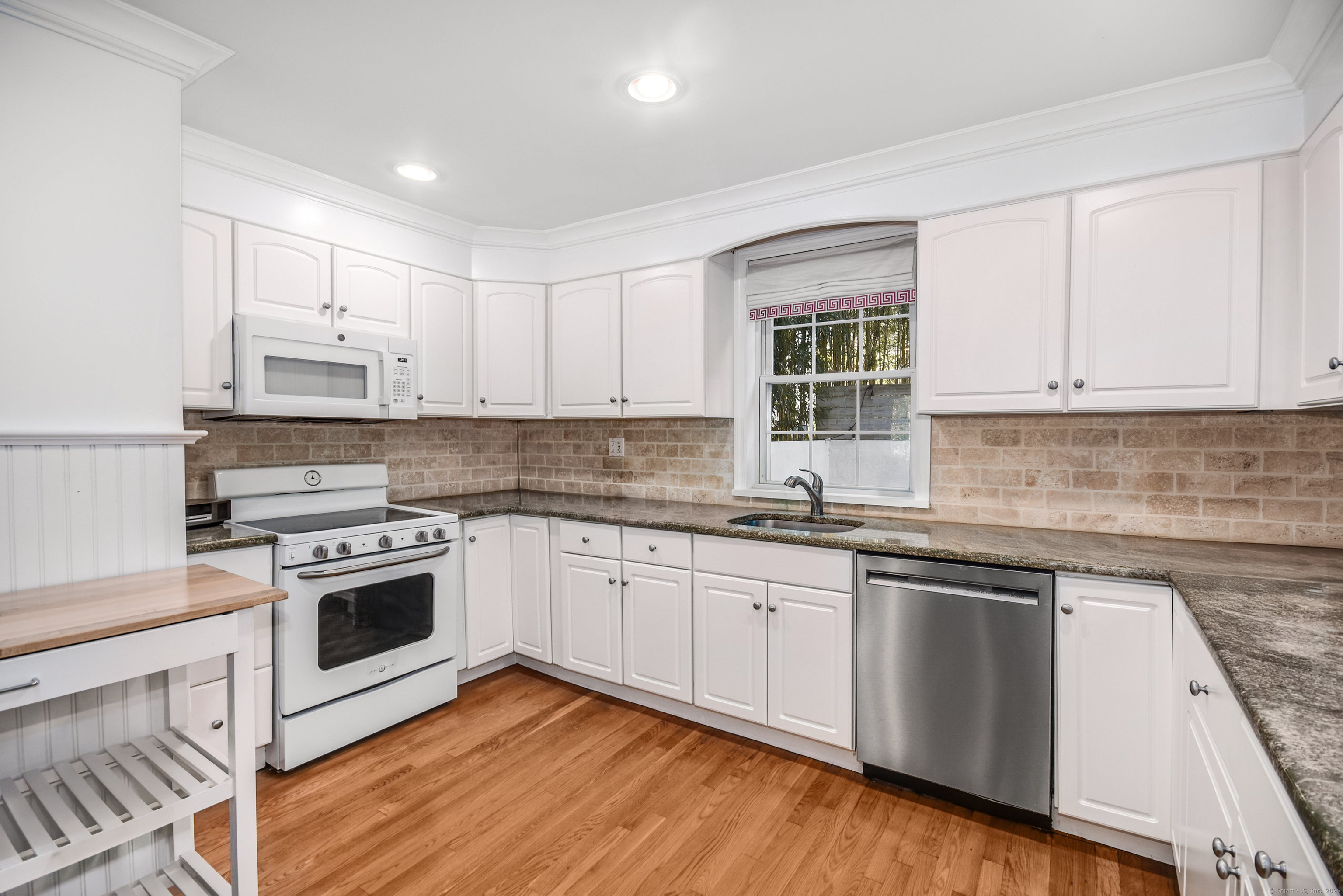 60 East Avenue New Canaan, CT 06840 - Photo 9 of 24 a kitchen with cabinets stainless steel appliances and wooden floor