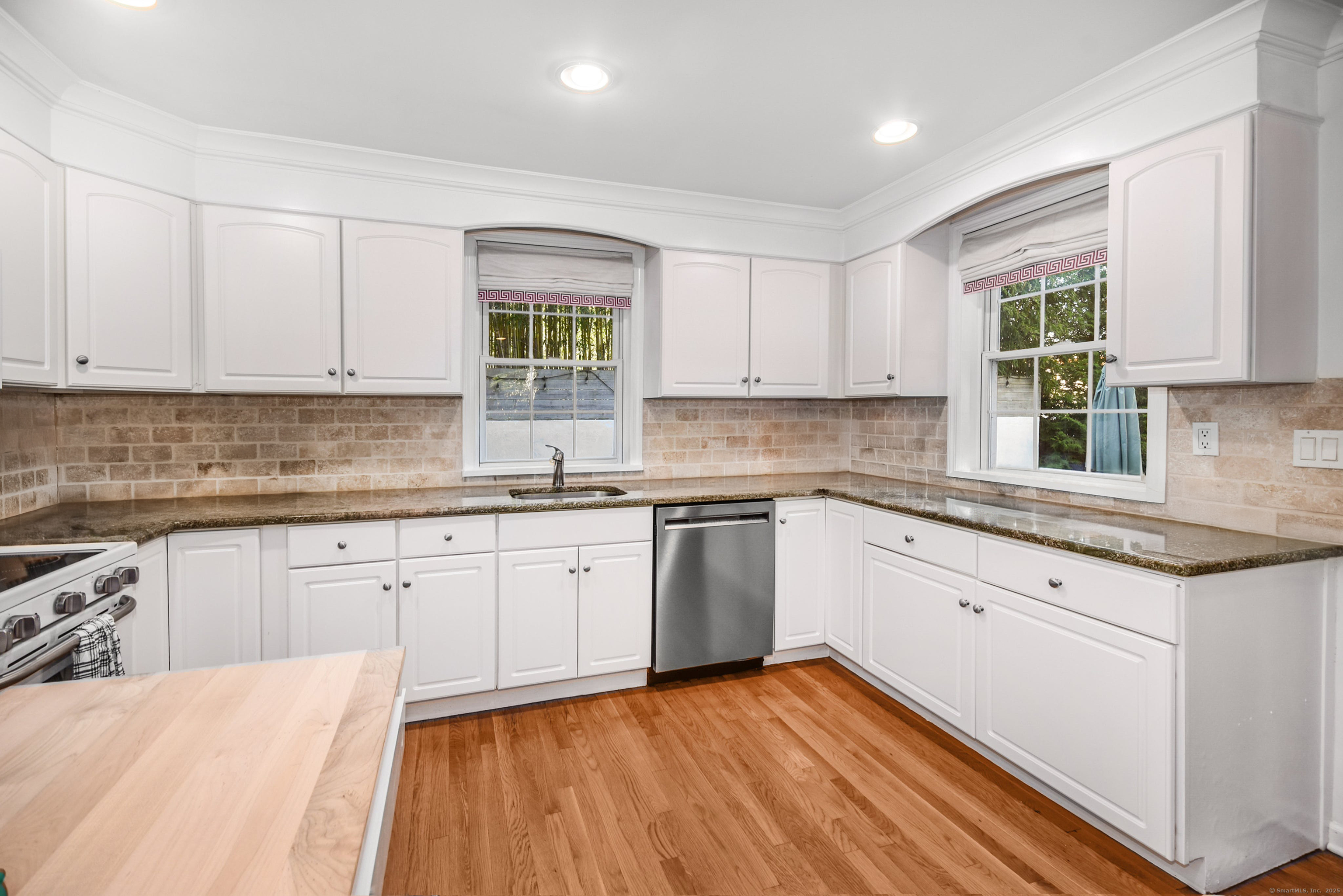 60 East Avenue New Canaan, CT 06840 - Photo 10 of 24 a kitchen with granite countertop cabinets stainless steel appliances a sink and a window