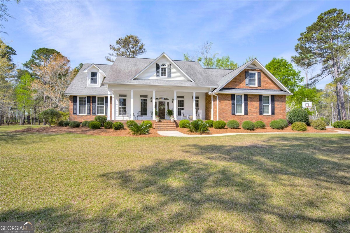 1490 Country Club Circle Wrens, GA 30833 - Photo 1 of 40 a front view of a house with a garden and plants