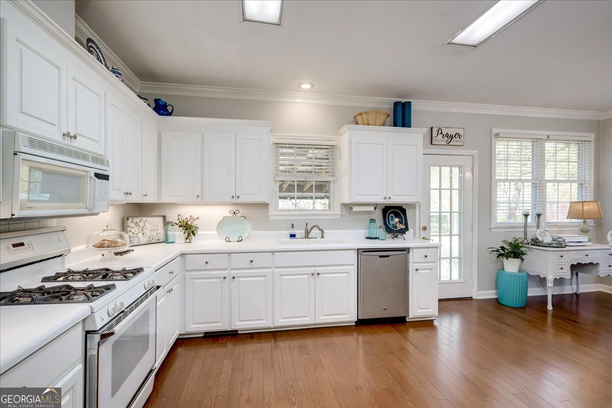 1490 Country Club Circle Wrens, GA 30833 - Photo 13 of 40 a kitchen with a sink white cabinets and white appliances