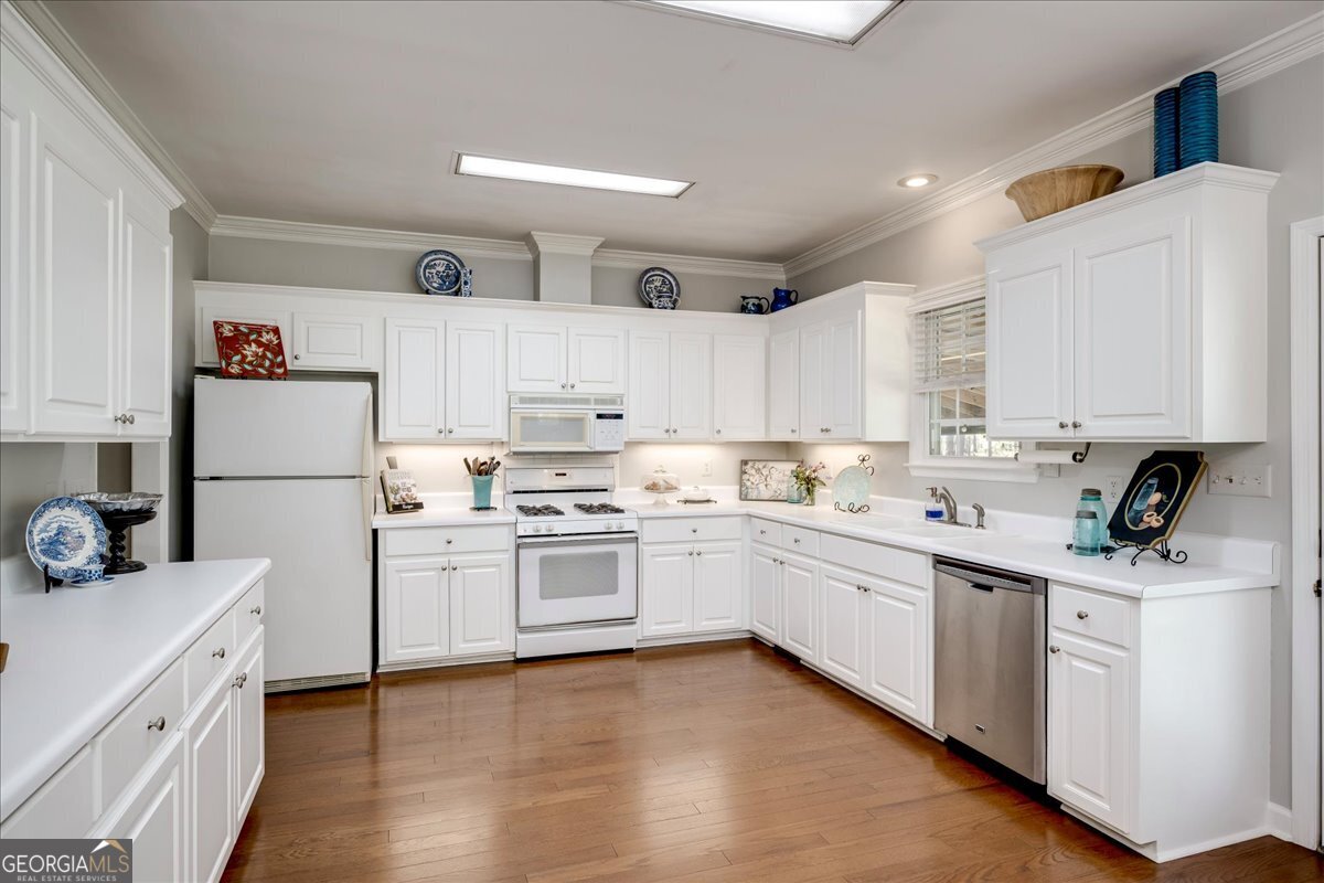 1490 Country Club Circle Wrens, GA 30833 - Photo 16 of 40 a kitchen with a sink white cabinets and white appliances