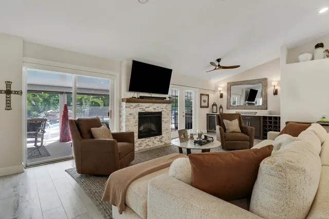 a living room with furniture kitchen view and a chandelier