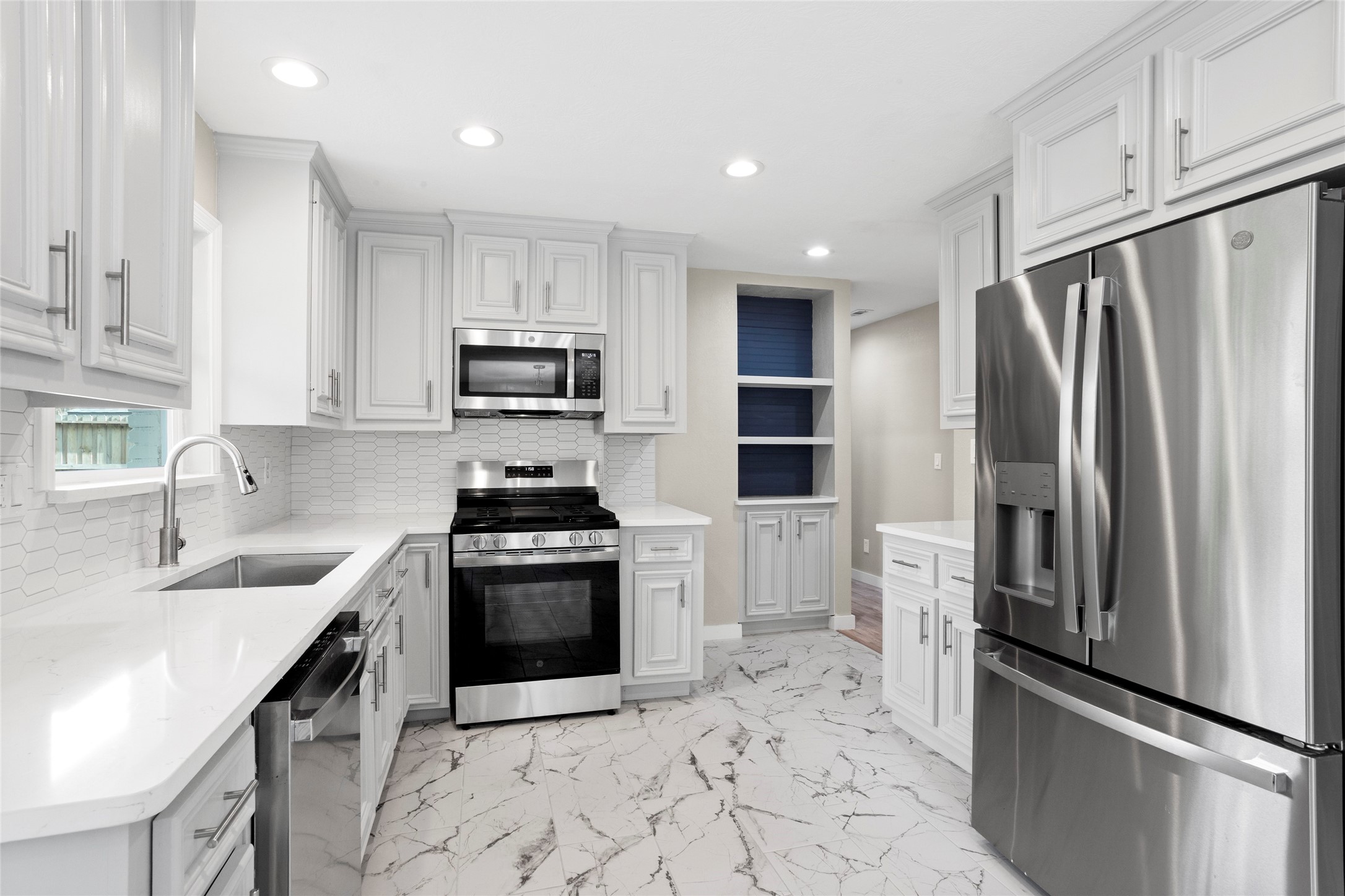 10127 Tolman Street Houston, TX 77034 - Photo 8 of 27 This modern kitchen features a bright, open-concept design with high-end finishes and updated stainless steel appliances.