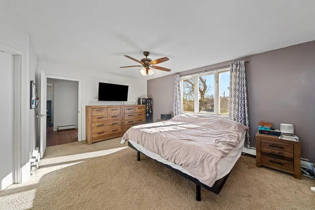 a bedroom with a bed flat screen tv and a fireplace