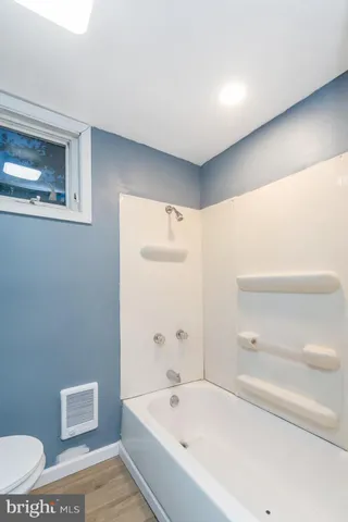a bathroom with a bathtub and a toilet