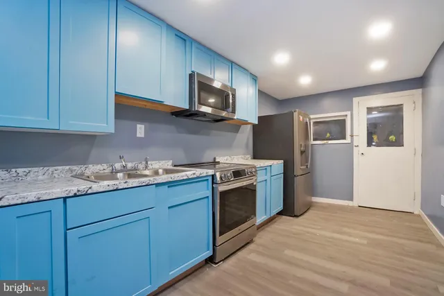 a kitchen with granite countertop wooden cabinets stainless steel appliances and a window