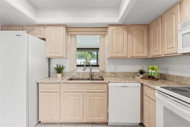 a kitchen with white cabinets and white appliances