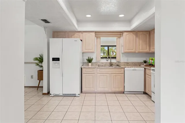 a kitchen with a refrigerator a sink and cabinets