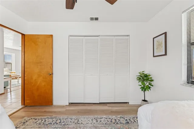 a view of a bedroom with wooden floor and a potted plant