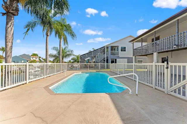 a view of a backyard with swimming pool and sitting area