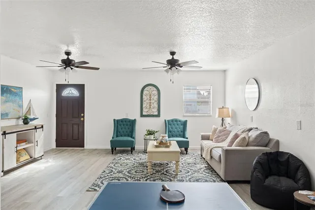 a living room with furniture a fireplace and a chandelier