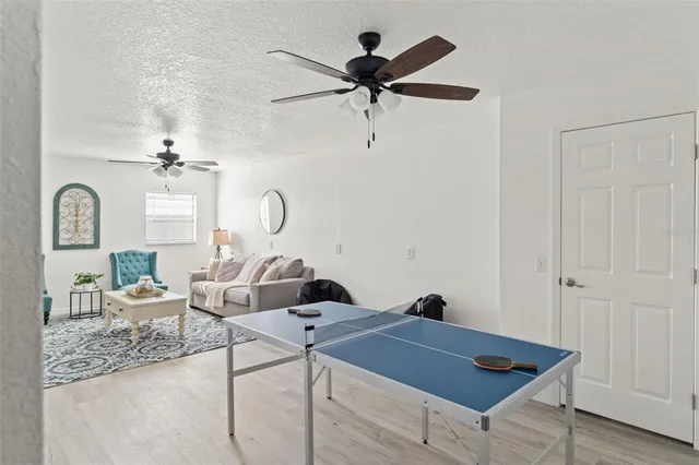a living room with couches a fireplace and a potted plant