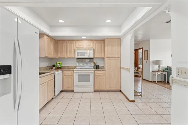 a kitchen with white cabinets and white appliances