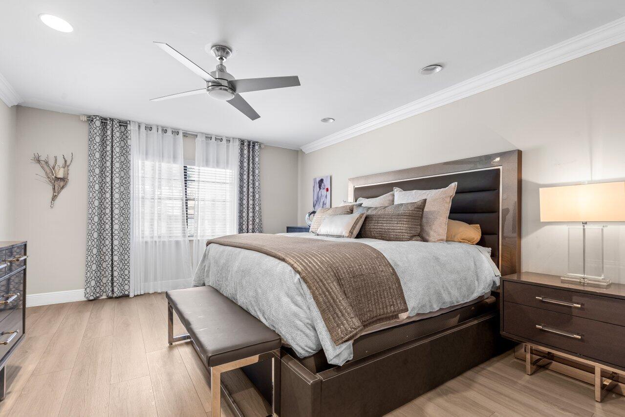 9261 Vista Del Lago, Unit H Boca Raton, FL 33428 - Photo 18 of 27 a bedroom with a bed and wooden floor