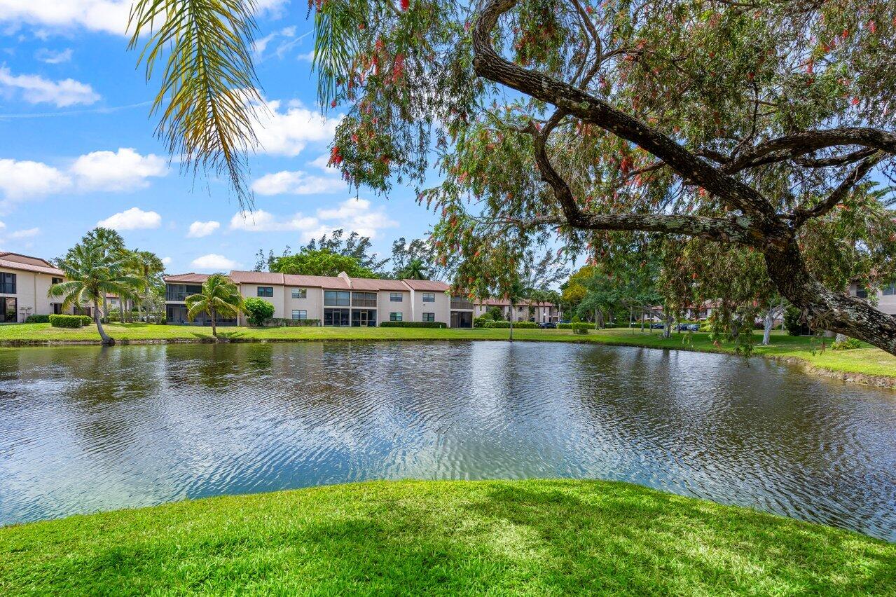 9261 Vista Del Lago, Unit H Boca Raton, FL 33428 - Photo 26 of 27 a view of a lake with a yard