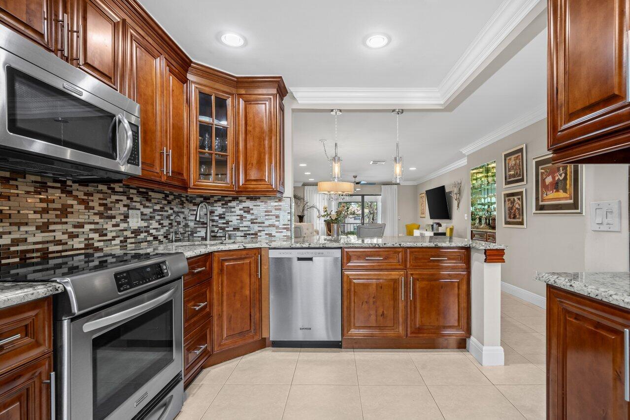 9261 Vista Del Lago, Unit H Boca Raton, FL 33428 - Photo 3 of 27 a kitchen with stainless steel appliances granite countertop a stove and a microwave
