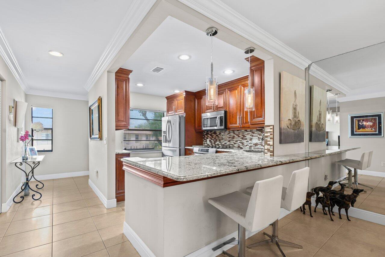 9261 Vista Del Lago, Unit H Boca Raton, FL 33428 - Photo 5 of 27 a large kitchen with a table and chairs