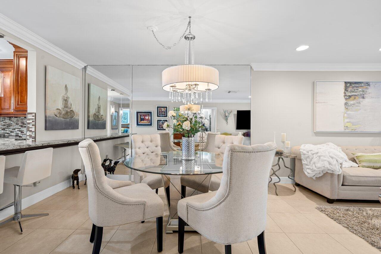 9261 Vista Del Lago, Unit H Boca Raton, FL 33428 - Photo 8 of 27 a dining room with furniture a chandelier and window