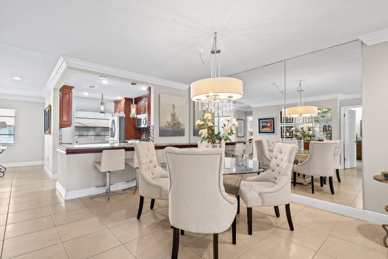 9261 Vista Del Lago, Unit H Boca Raton, FL 33428 - Photo 9 of 27 a view of a dining room and chandelier fan and kitchen view