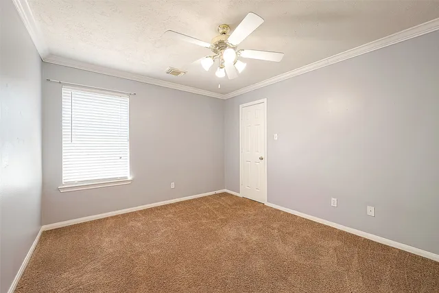 an empty room with windows and chandelier fan